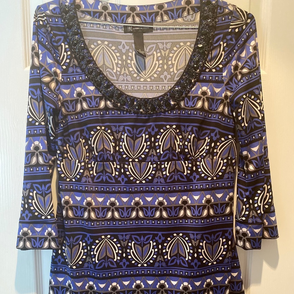 Inc blue multi colored shirt with black sequin rimmed neck.